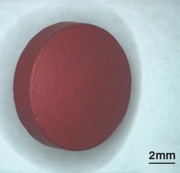 Figure 2: Light microscope image of tablet with surface coating (above), image of a section through a false coloured tablet reconstruction, revealing the coating thickness and distribution of active and excipient material (below)