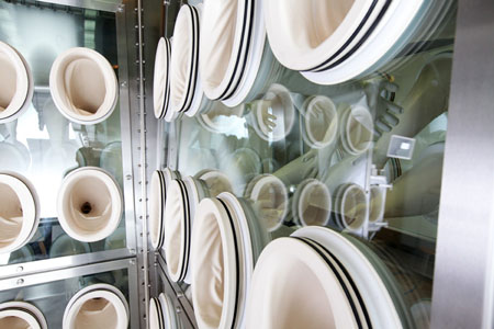 Contained cytotoxic installation for in-line clinical trial production
